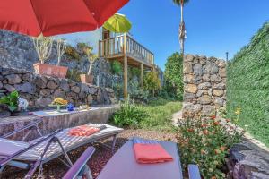 a patio with a table and chairs and an umbrella at Casa de Teja in La Orotava