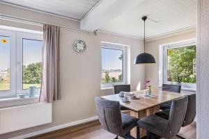 a dining room with a table and chairs and a clock at Jensenhof Pellworm in Pellworm