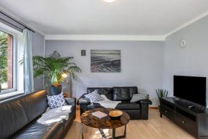 a living room with a leather couch and a table at Jensenhof Pellworm in Pellworm