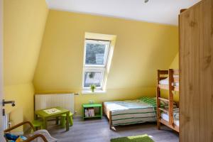 a yellow room with two bunk beds and a window at Jensenhof Pellworm in Pellworm
