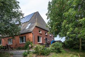 a red brick house with a solar roof at Jensenhof Pellworm in Pellworm