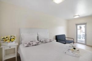 a white bedroom with a bed and a chair at Numar Residence Villa Z in Manta Rota +18 photos