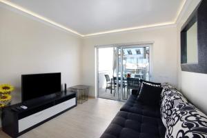 a living room with a couch and a flat screen tv at Numar Residence Villa Z in Manta Rota