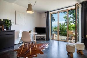 a living room with a table and chairs and a sliding glass door at La casa nel verde in Lindau