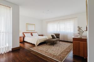 a bedroom with a bed and a chair at Viana Beach Surf House in Viana do Castelo +30 photos