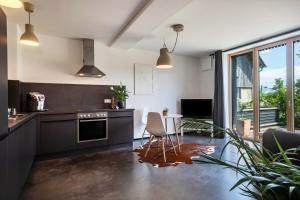 a kitchen with black cabinets and a table and chairs at La casa nel verde in Lindau +12 photos
