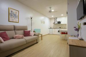 a living room with a couch and a kitchen at Sophie Apartamentos - Burela in Burela de Cabo