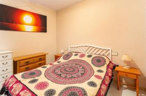 a bedroom with a bed and a dresser and a bedspread at Navgts5p33-1 in Torrevieja