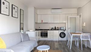 a living room with a couch and a table and a kitchen at Costa Nova Ocean View in Gafanha da Encarnação