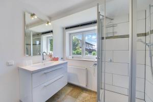 a white bathroom with a sink and a shower at Fewo Trudi in Grabenstätt +17 photos
