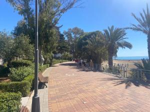 a group of people walking down a brick sidewalk at Las fuentes in Alcossebre