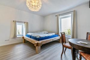 a bedroom with a bed and a table and windows at Gutgemacht in Sankt Annen