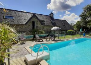a swimming pool in front of a house at Longère de Nivinen in Arzano