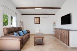 a living room with a brown couch and a table at Casa Naranjos in El Soto