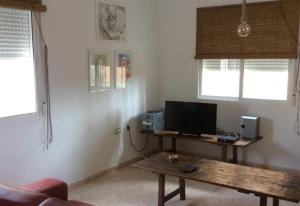 a living room with a table with a computer on it at Casa Cuesta in Bolnuevo