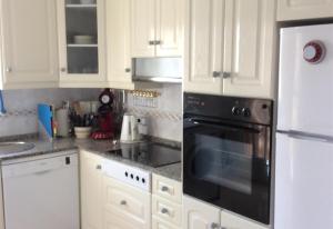 a kitchen with white cabinets and a black oven at Casa Cuesta in Bolnuevo +10 photos