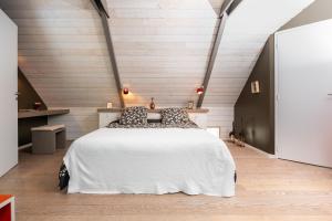 a bedroom with a large white bed in a loft at Longère de Nivinen in Arzano +77 photos
