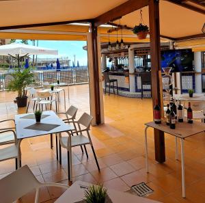 a restaurant with tables and chairs and a patio at Stunning Sunset Ocean View Apt in Taurito