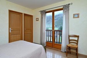 a bedroom with a bed and a window with a balcony at Les Hélianthèmes in Guchen