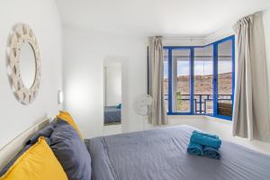 a bedroom with a bed and a large window at Stunning Sunset Ocean View Apt in Taurito +30 photos