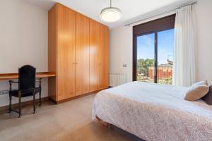 a bedroom with a bed and a desk and a window at Casa Tico in Roda de Bará +27 photos