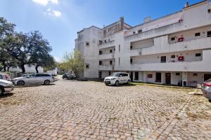 a parking lot with cars parked in front of a building at Amazing Oura Beach Apartment in Albufeira