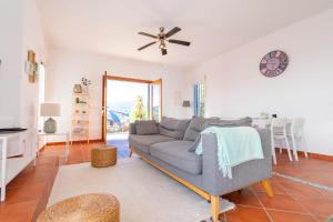 a living room with a couch and a ceiling fan at Casa Arco Iris in Cómpeta