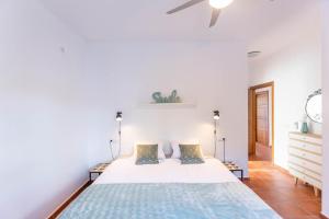 a white bedroom with a large bed in a room at Casa Arco Iris in Cómpeta +8 photos