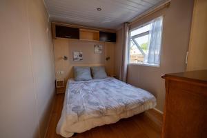 a small bedroom with a bed and a window at Mobilehome 4 personnes in Les Mathes