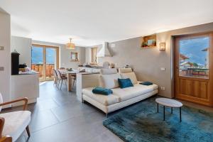 a living room with a white couch and a kitchen at Chalet Sambor in Oga