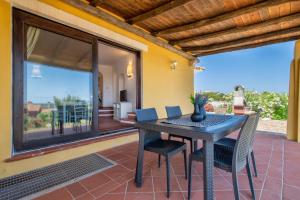 a dining room table and chairs on a patio at Villa Azzurra in Stintino
