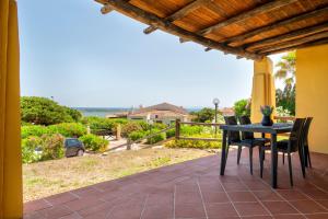 a table and chairs on a patio with a view of the ocean at Villa Azzurra in Stintino