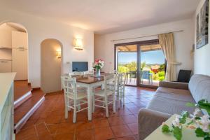 a living room with a table and chairs and a couch at Villa Azzurra in Stintino