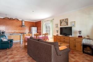 a living room with a couch and a tv and a kitchen at Las Alas del Sol in Vejer de la Frontera