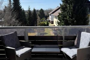 two chairs and a table on a balcony at Wurmbergzauber Sonnenschein in Braunlage
