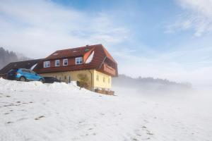 a house with a car parked in front of it in the snow at Ferienwohnung Sonnenstüble in Titisee-Neustadt