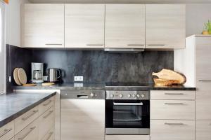 a kitchen with white cabinets and a black oven at Ferienwohnung Sonnenstüble in Titisee-Neustadt