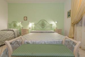 a bedroom with a large bed with a green headboard at Il Girasole - Mirto in Venturina Terme +25 photos
