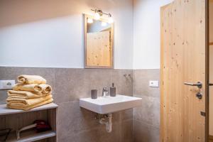 a bathroom with a sink and a mirror and towels at Oberpatiglhof - Lukas in Brie +22 photos
