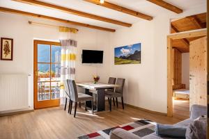 a living room with a table and chairs and a television at Oberpatiglhof - Lukas in Brie