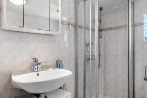 a white bathroom with a sink and a shower at Ferienanlage Kappeln-Kopperby in Kopperby +12 photos