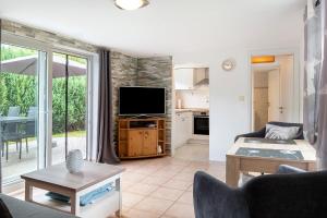 a living room with a couch and a tv at Ferienanlage Kappeln-Kopperby in Kopperby