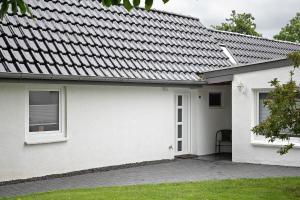 a white house with a metal roof at Ferienanlage Kappeln-Kopperby in Kopperby