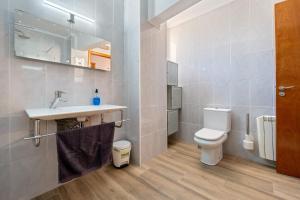a bathroom with a white toilet and a sink at La Garrofera in Aldover +19 photos