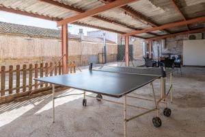 a ping pong table sitting inside of a building at La Garrofera in Aldover