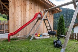 a playground with a red slide in a yard at Oberpatiglhof - Lukas in Brie
