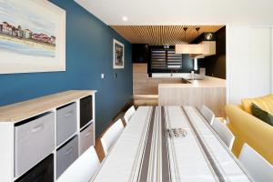 a dining room with a table and a couch at Etxe Ttippi in Saint-Jean-de-Luz