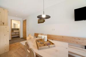 a dining room with a table with candles and a tv at Herrischner Apartement 1 in Moso