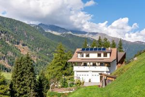 a house with solar panels on the side of a hill at Glocklechnhof Sternenhimmel in Cadipietra