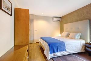 a bedroom with a large bed with a blue blanket at Casa dos Pinheiros in Apúlia